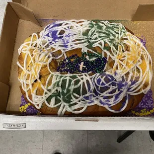 king cake decorated with icing and sprinkles