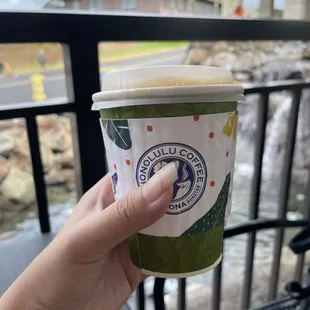 a hand holding a coffee cup