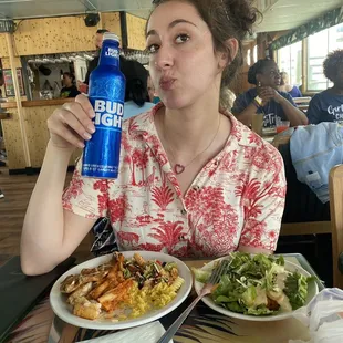 a woman sitting at a table with food and drink