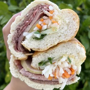 a person holding a sandwich in their hand
