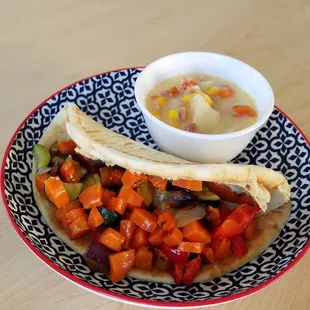 a bowl of soup and a pita sandwich