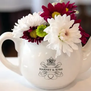 a teapot with flowers in it