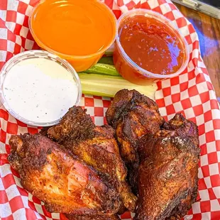 a plate of chicken wings and dippings