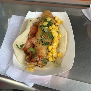 a hot dog with corn and lettuce