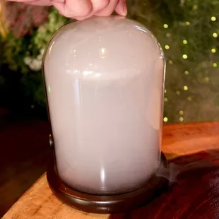 The Smoke on the Water was made with Mezcal, Genepy, rhum agricole, and lime - served in a coup glass in a smoke filled cloche.