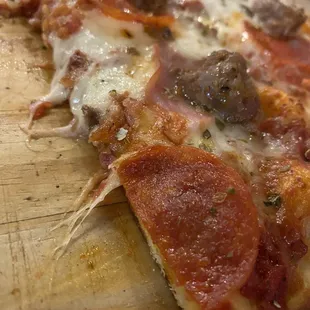 Yummy thin crust Godfather (meaty) pizza with great sauce.