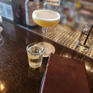 a drink and a notebook on a bar