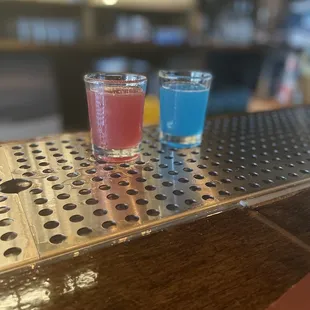 two shot glasses on a bar top