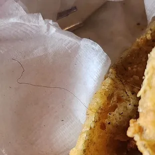 Black hair cooked into fish filet.