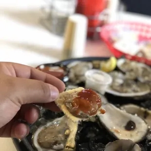 a person picking a piece of oyster