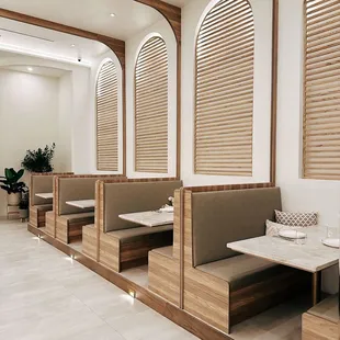 a dining area with wooden booths and white walls