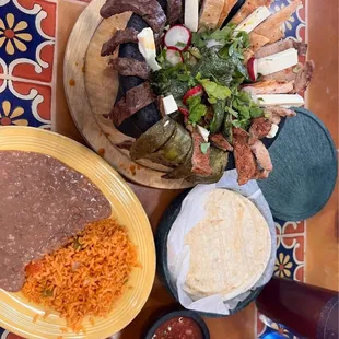 MOLCAJATE grilled pork, "arrachera steak", chicken, onions, cactus leaves, jalapeños, and radishes.
