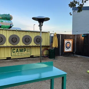 a man sitting on a bench in front of a green table