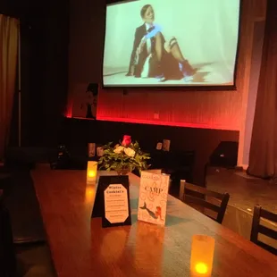 a woman sitting on a table in front of a projector screen
