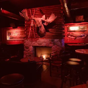 Right side of the bar area after walking in the front door, with the fireplace the main highlight. TVs along the wall to the right as well.