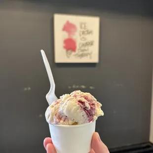 a hand holding a cup of ice cream