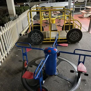 an empty playground with a car parked in the background