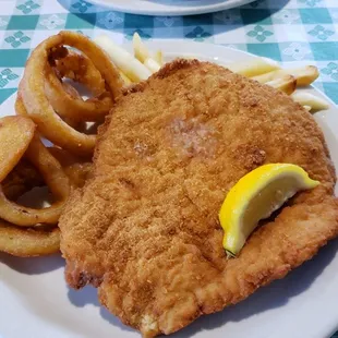 Jager Schnitzel with fries &amp; onion rings in the foreground...fries and coleslaw in the background.