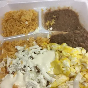 Chilaquiles with sour cream, cheese and onions, rice, beans and scrambled eggs. To go.