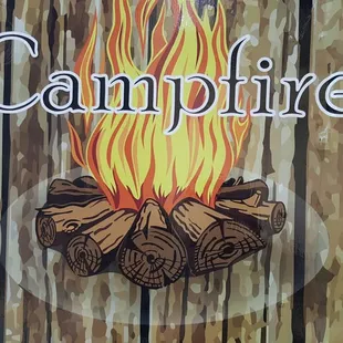 a campfire sign on a wooden fence