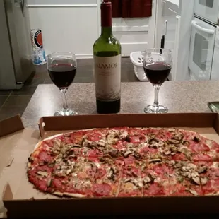 Delivery of excellent pizza and wine! Mushroom,  pepperoni and green olives.