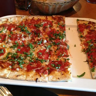 Pepperoni, white onion, basil after cooking. The crust is thin, but delicious. The sauce is sweet. Altogether very tasty!