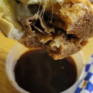 a hand holding a half eaten sandwich