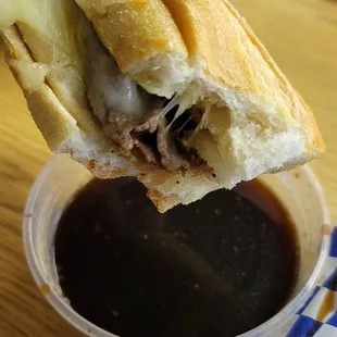 a hand holding a half eaten sandwich