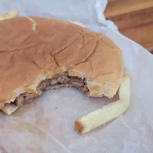 Cheese burger next to fry.