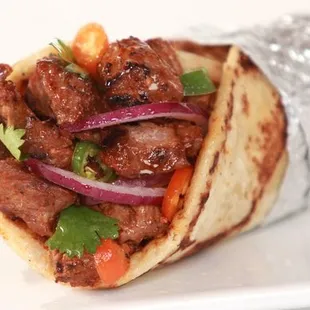 a closeup of a meat and vegetable burrito