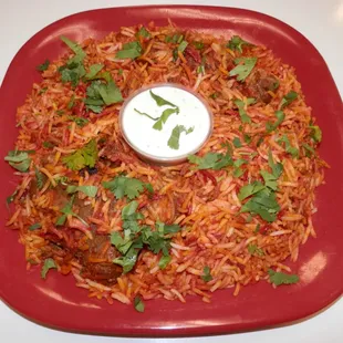 a red plate of food with a white sauce