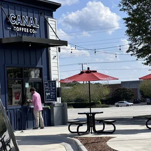 a woman standing in front of a coffee shop