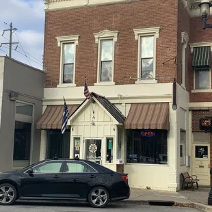 a black car parked in front of a brick building