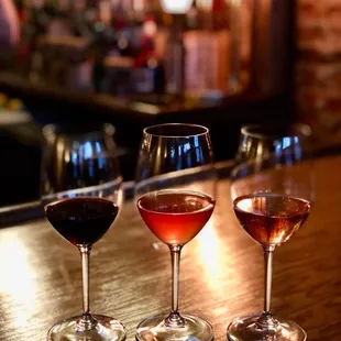 three glasses of wine on a bar