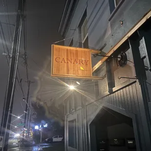 a restaurant sign hanging from the side of a building