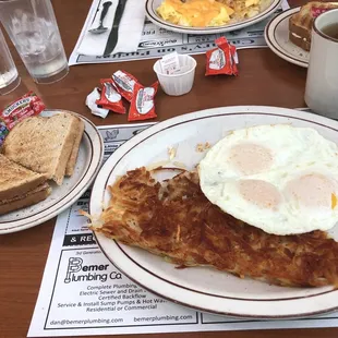 a breakfast of eggs, hash browns and toast
