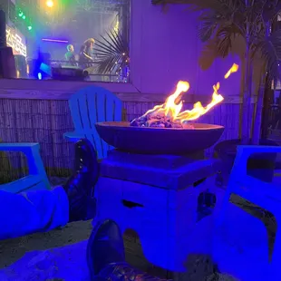 a person's feet in front of a fire pit