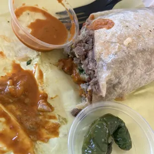 Carne Asada burrito with salsa and a pepper.