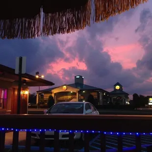 a car parked under a thatched umbrella