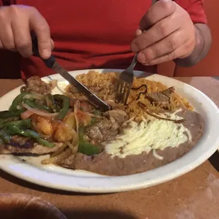 Steak with peppers and onions, refríed beans and rice.
