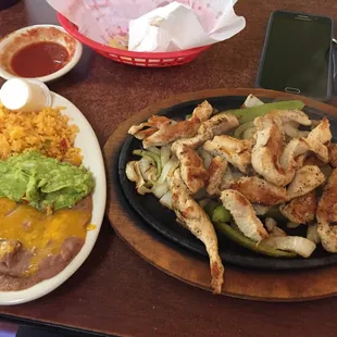 a plate of chicken and a plate of beans and rice