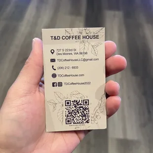 a hand holding a business card