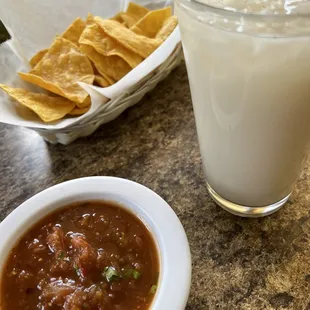 a bowl of salsa and a glass of milk