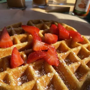 a waffle with strawberries and powdered sugar