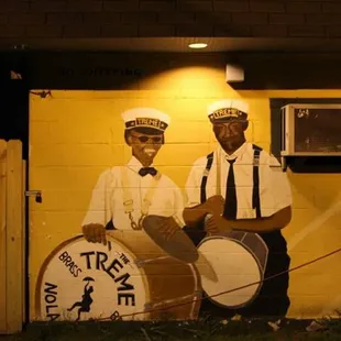 two men in sailor's uniforms with a drum
