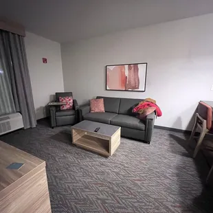 Living room wirh eat in kitchen/bar. Large tv and a desk with chair