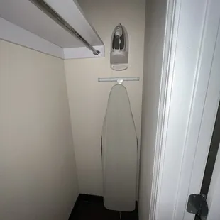 Spacious closet with iron and board.