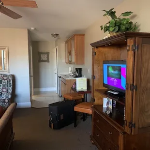 Kitchenette with microwave, refrigerator, coffeemaker, sink and dishes.