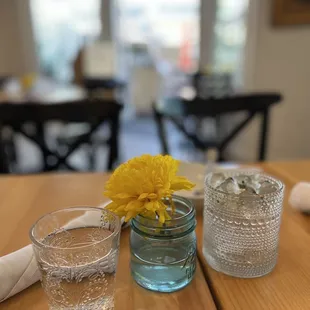 a glass of water and a yellow flower