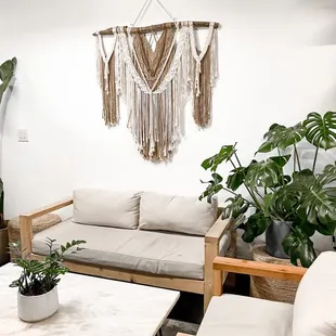 a living room with a couch, coffee table, and potted plants